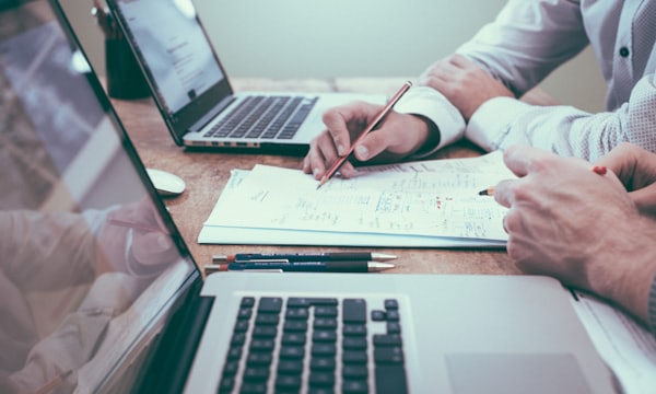 Consultants reviewing procurement documents at a meeting table